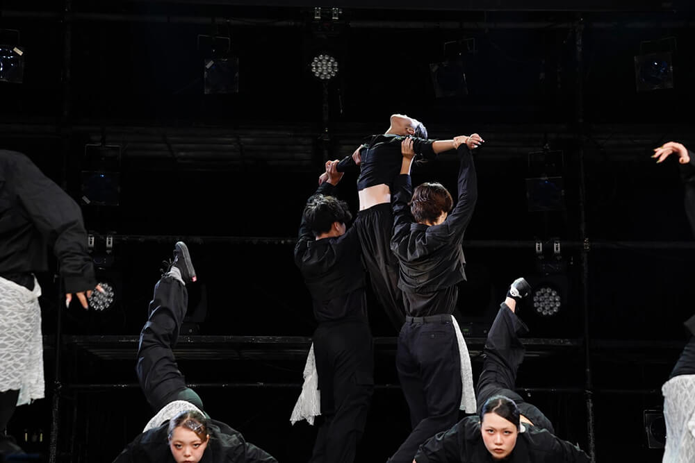 腕を広げ持ち上げられた女性