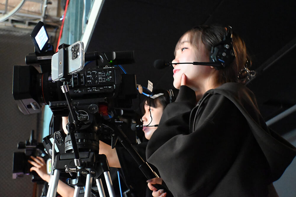 ビデオカメラで動画撮影をしている映像学科の女子学生